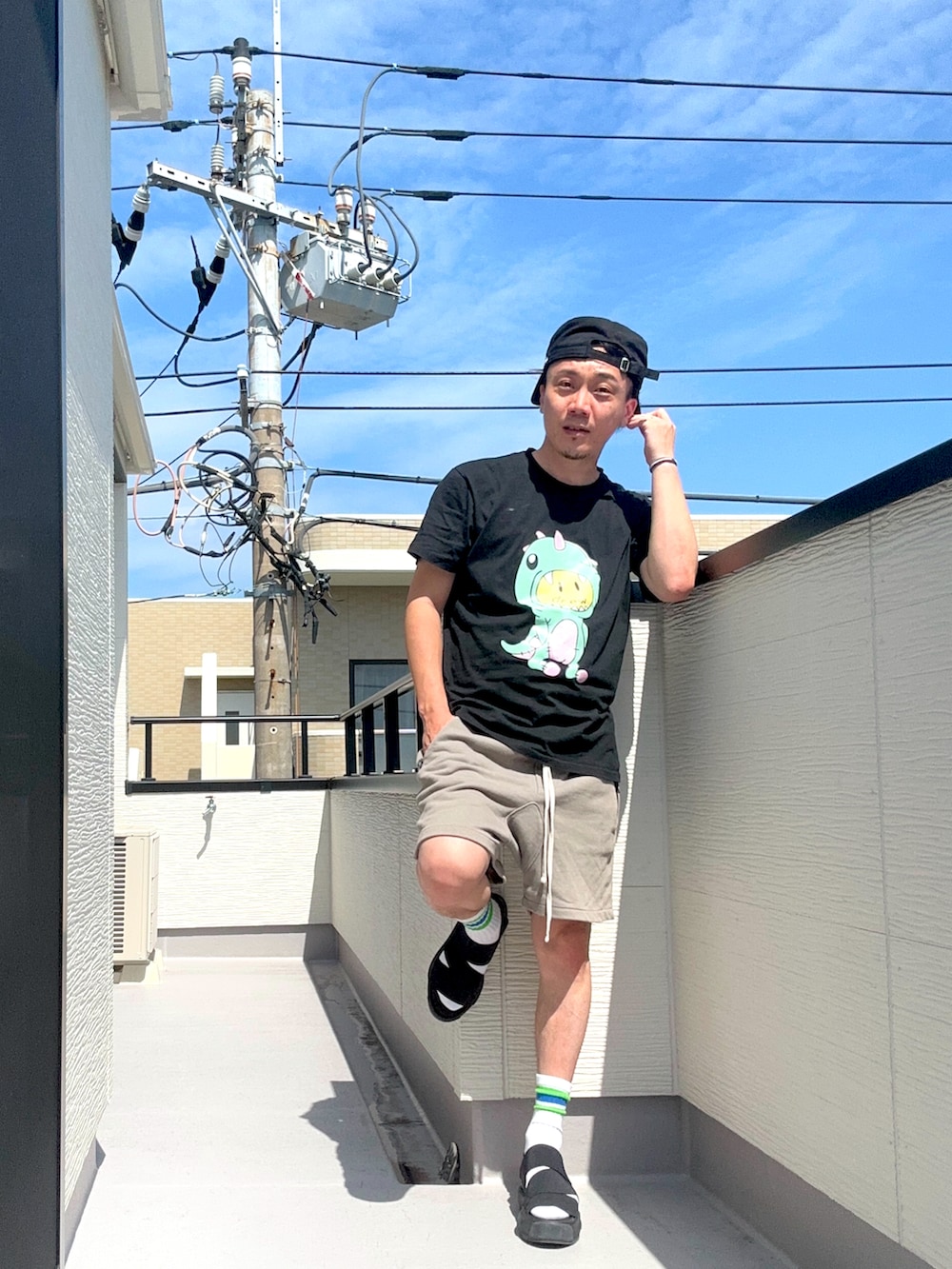 ブラック系のTシャツ/カットソー、グレー系のスウェットパンツ、ブラック系のサンダルを着用したメンズの夏コーディネートの3枚目の写真
