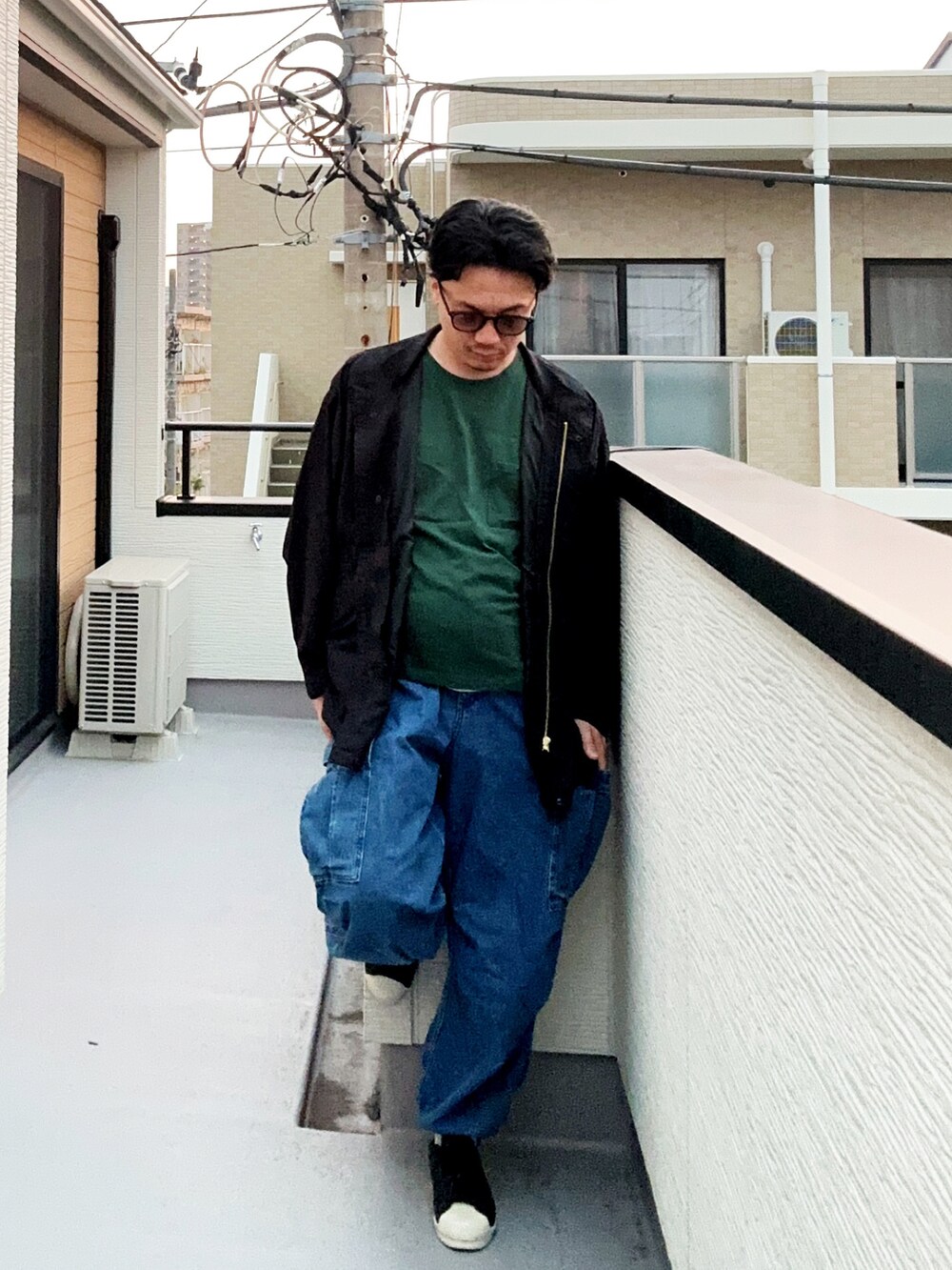 グリーン系のTシャツ/カットソー、ブラック系のブルゾン、ブルー系のカーゴパンツを着用したメンズの秋コーディネートの3枚目の写真