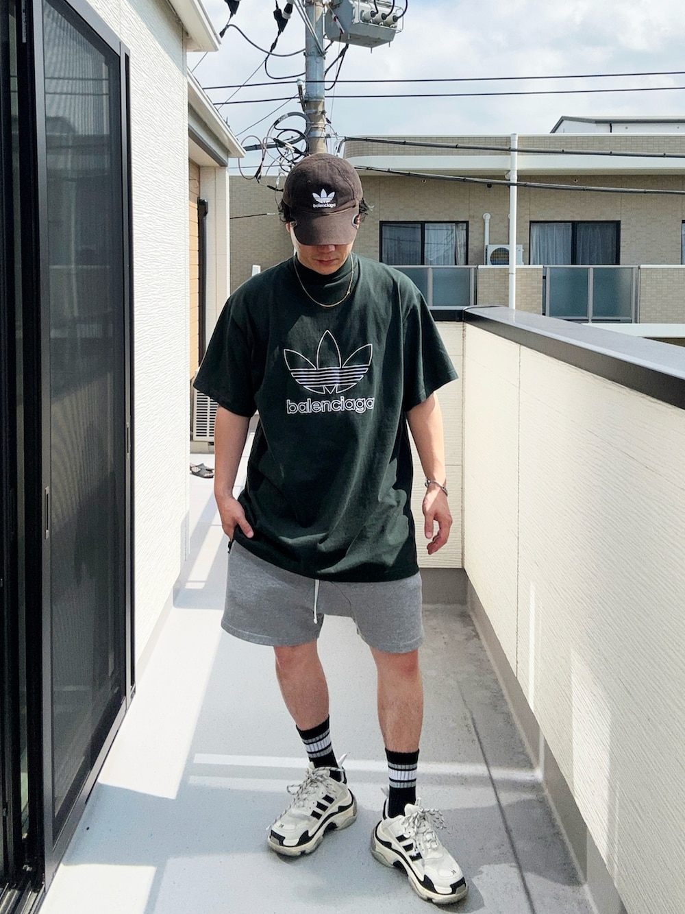 グリーン系のTシャツ/カットソー、グレー系のパンツ、ホワイト系のシューズを着用したメンズの秋コーディネートの3枚目の写真