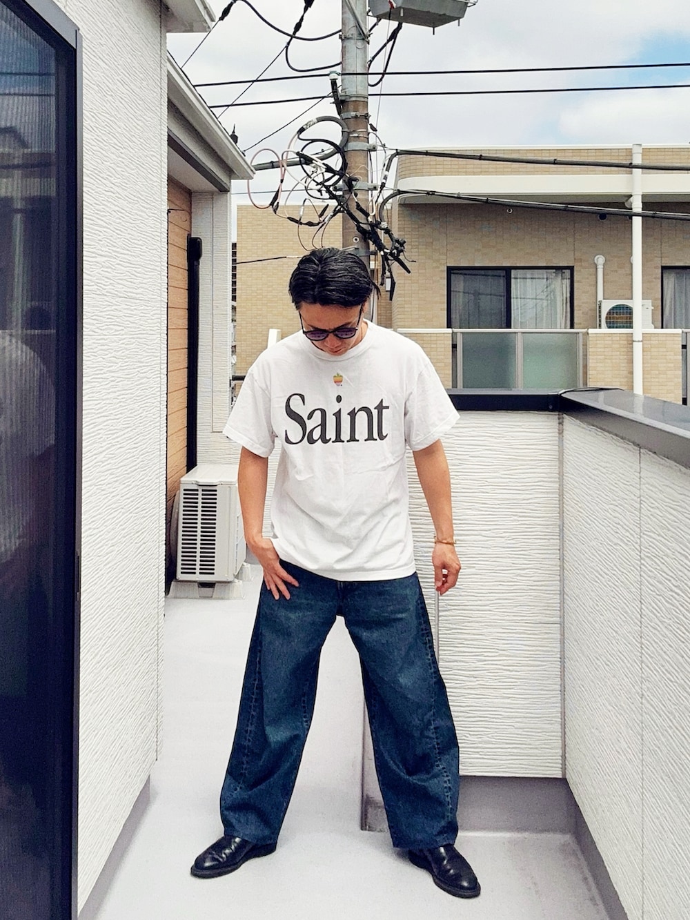 ホワイト系のTシャツ/カットソー、ブルー系のデニムパンツ、ブラック系のブーツを着用したメンズの夏コーディネートの3枚目の写真