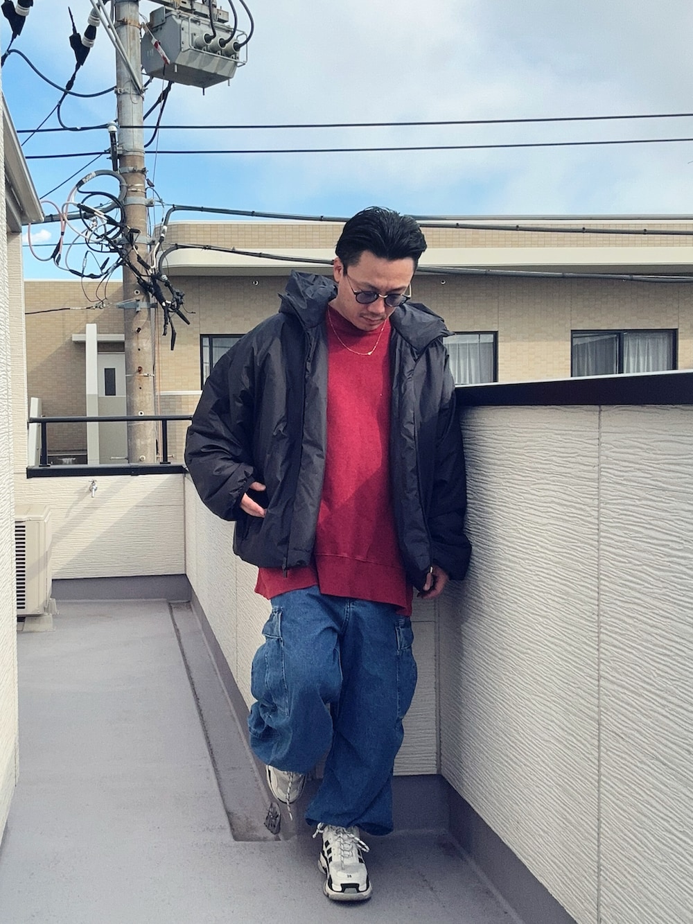 レッド系のスウェット、ブラック系のジャケット/アウター、ブルー系のカーゴパンツを着用したメンズの冬コーディネートの2枚目の写真