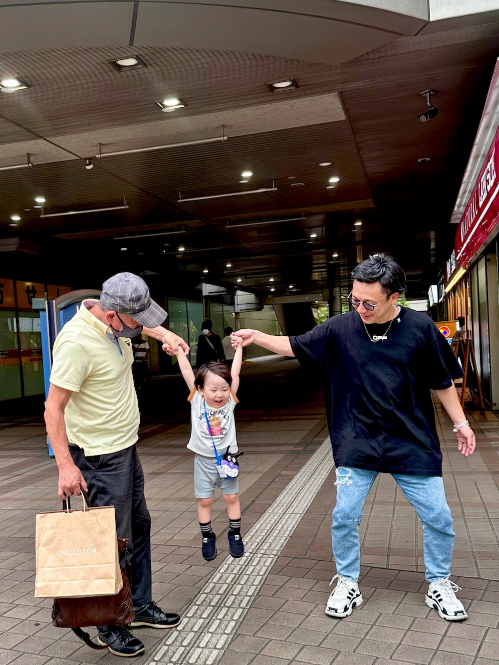 ブルー系のデニムパンツ、ブラック系のTシャツ/カットソー、ホワイト系のシューズを着用したメンズの秋コーディネートの2枚目の写真
