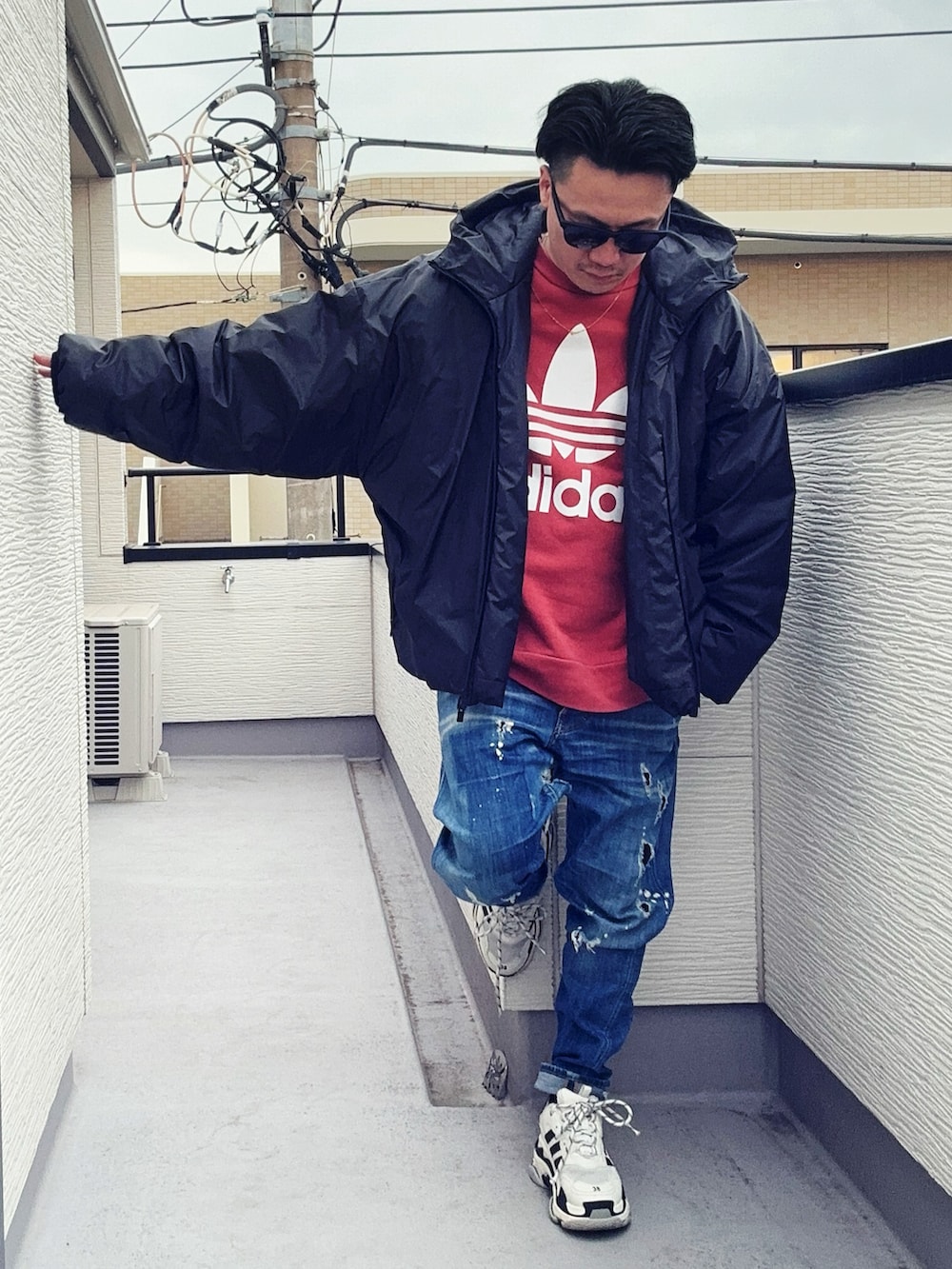 オレンジ系のスウェット、ブルー系のデニムパンツ、ブラック系のジャケット/アウターを着用したメンズの冬コーディネートの3枚目の写真