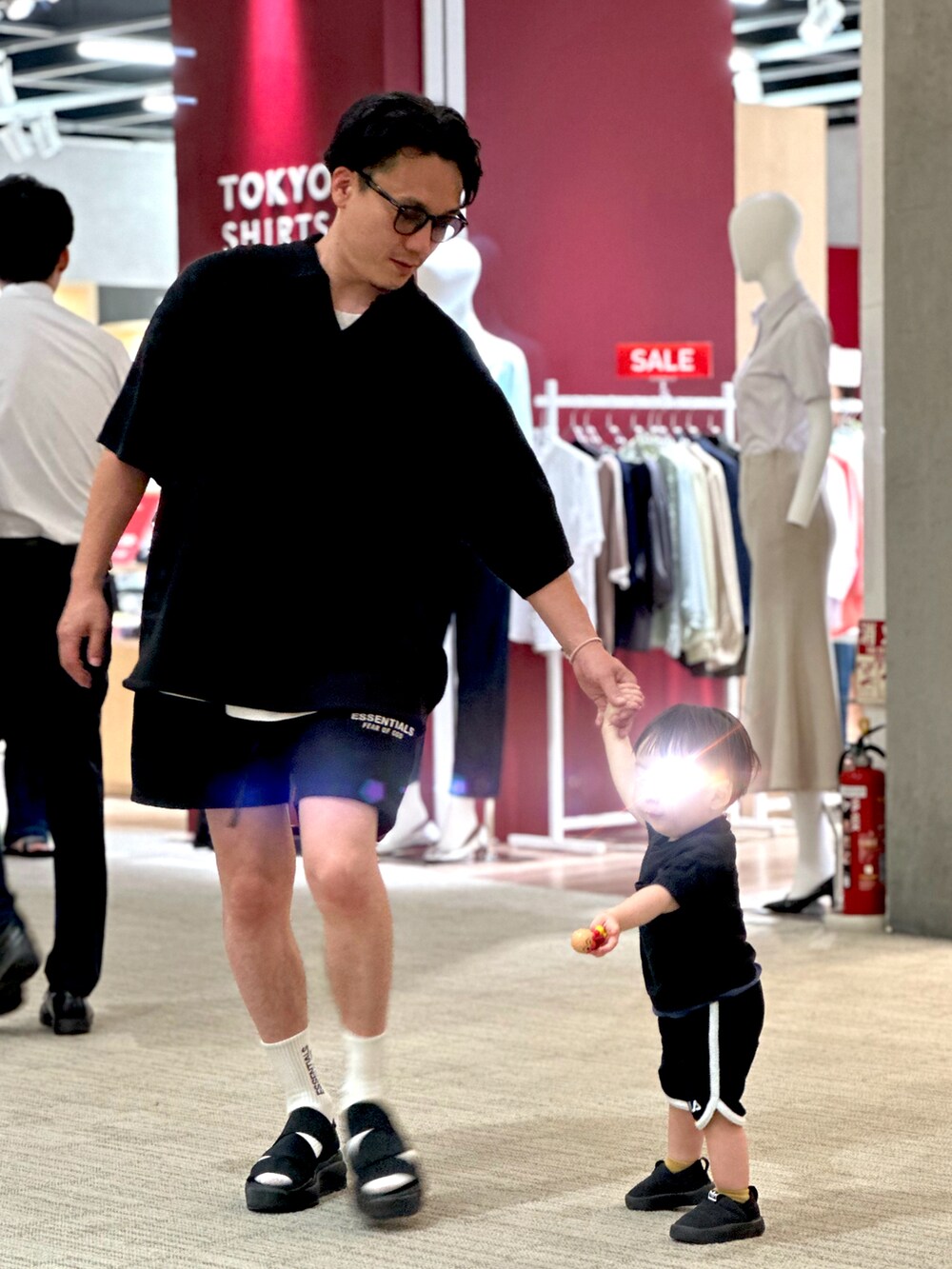 ブラック系のポロシャツ、ブラック系のスウェットパンツ、ブラック系のサンダルを着用したメンズの夏コーディネートの3枚目の写真