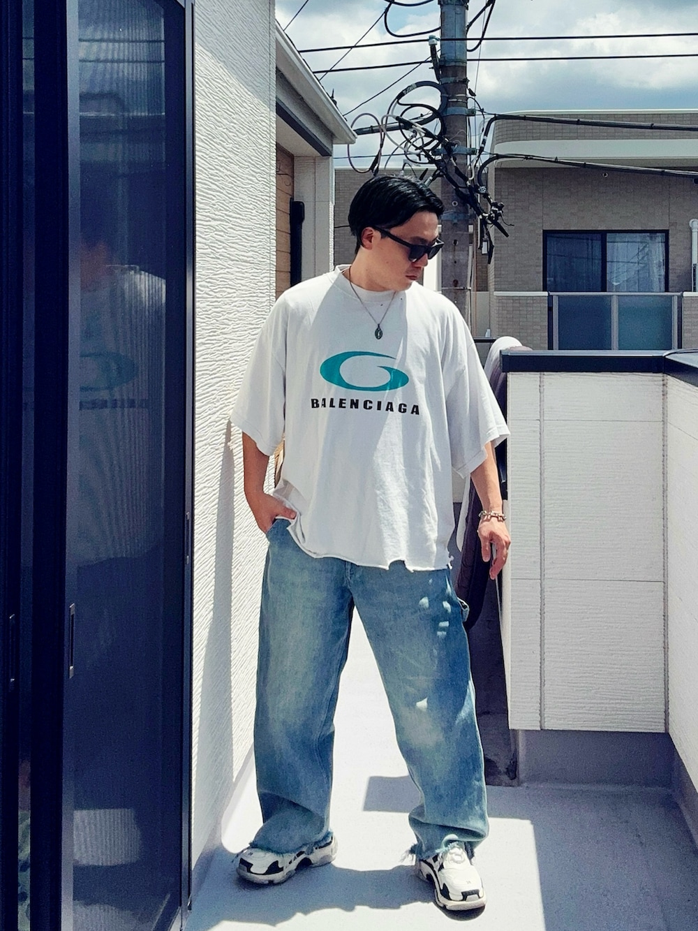 ブルー系のデニムパンツ、ホワイト系のTシャツ/カットソー、ホワイト系のシューズを着用したメンズの夏コーディネートの3枚目の写真