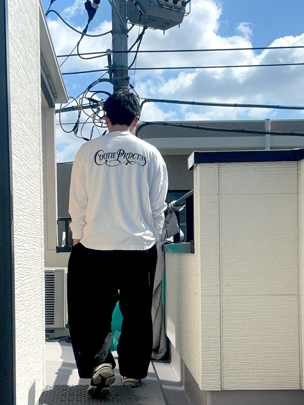 ブラック系のスウェットパンツ、ホワイト系のTシャツ/カットソー、ホワイト系のシューズを着用したメンズの秋コーディネートの3枚目の写真