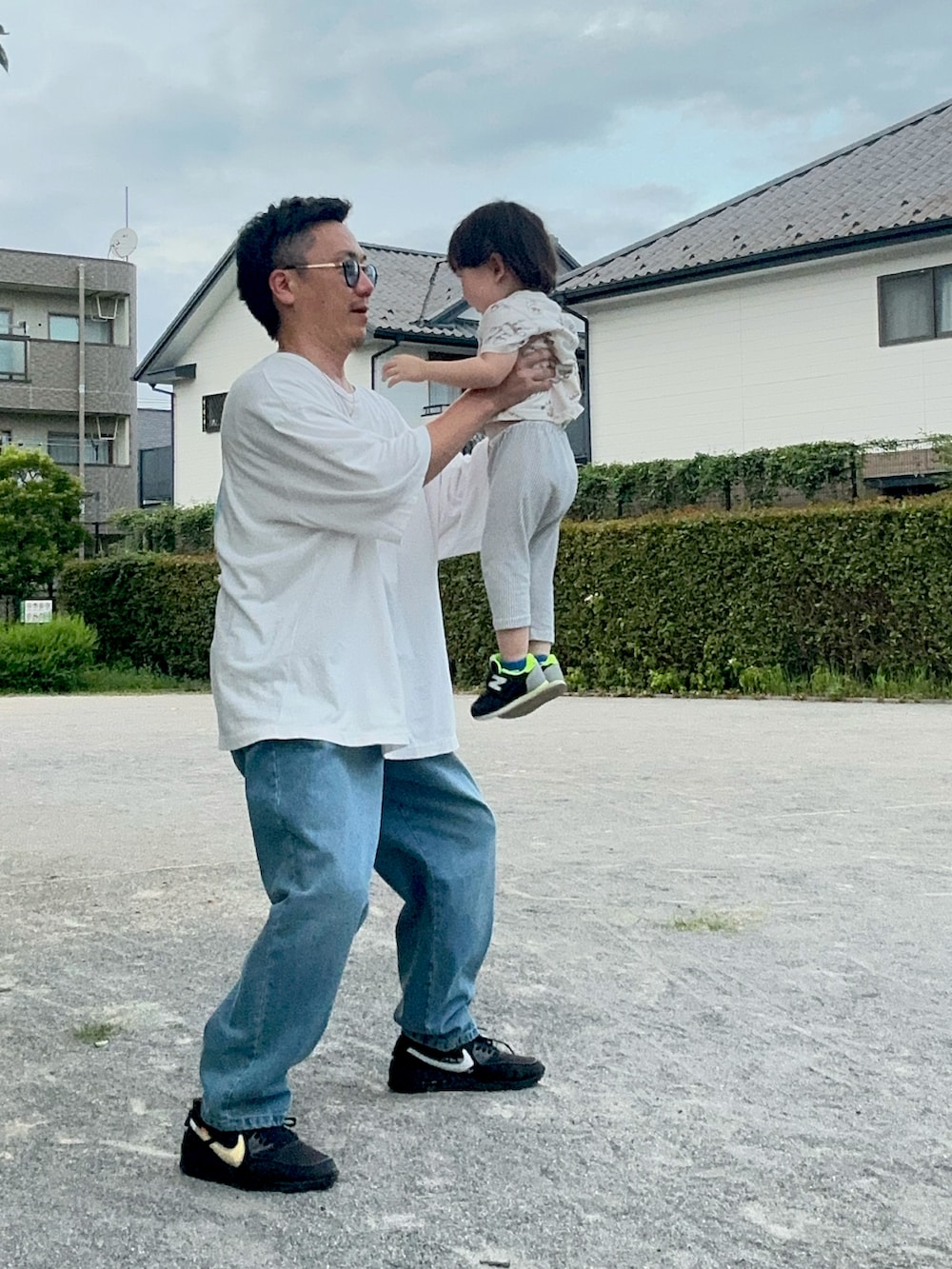 ホワイト系のTシャツ/カットソー、ブルー系のデニムパンツ、ブラック系のスニーカーを着用したメンズの夏コーディネートの3枚目の写真