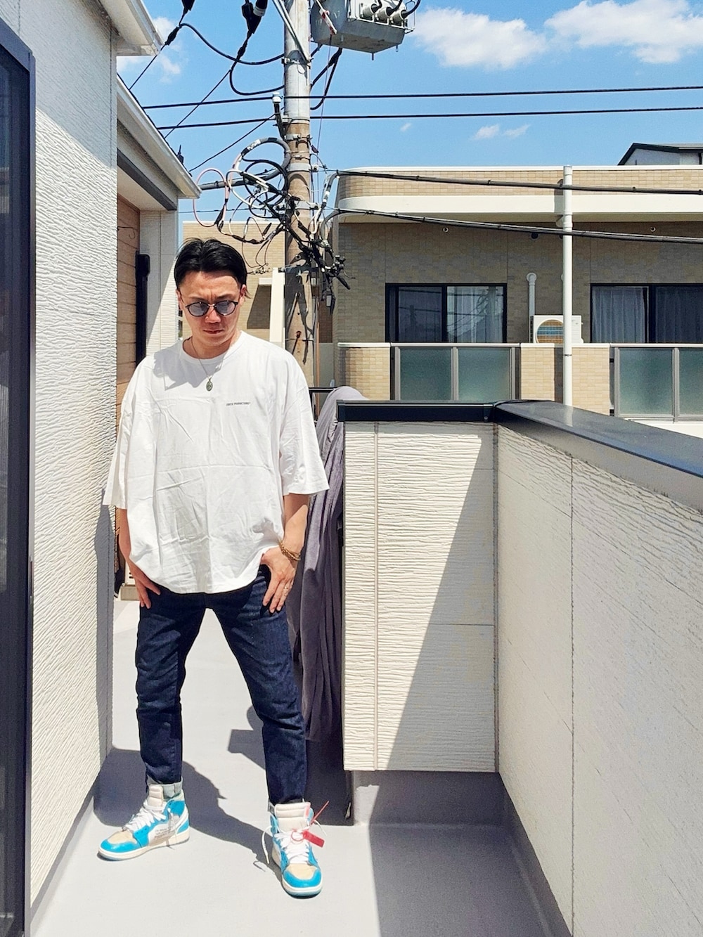 ホワイト系のTシャツ/カットソー、ブルー系のデニムパンツ、ブルー系のスニーカーを着用したメンズの春コーディネートの2枚目の写真