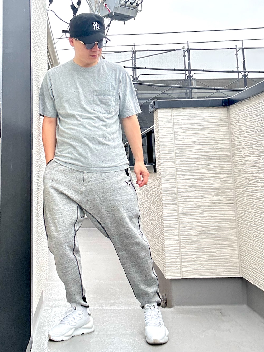 グレー系のTシャツ/カットソー、グレー系のパンツ、ホワイト系のスニーカーを着用したメンズの夏コーディネートの2枚目の写真
