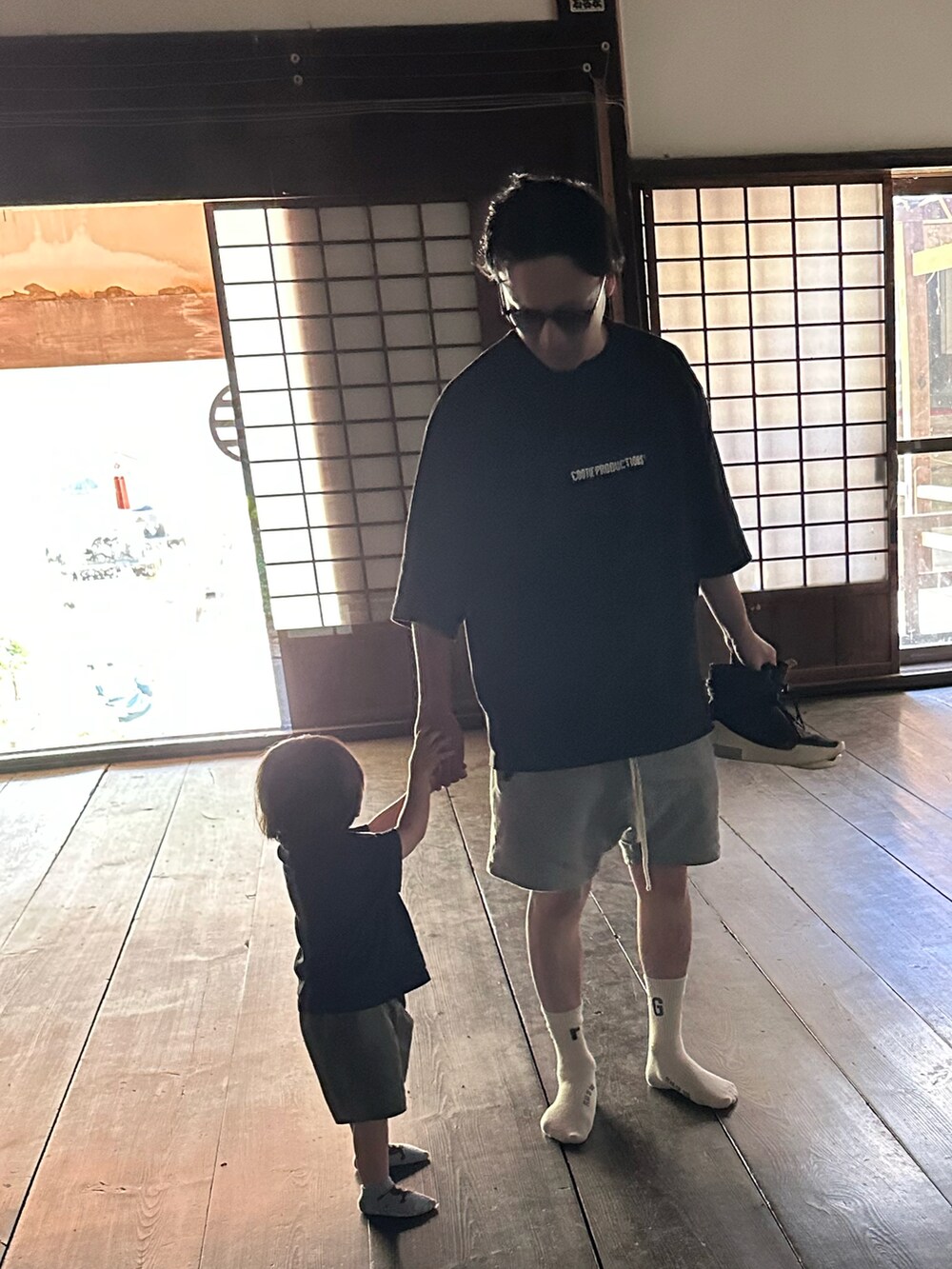 ブラック系のTシャツ/カットソー、グレー系のパンツ、ブラック系のスニーカーを着用したメンズの春コーディネートの2枚目の写真