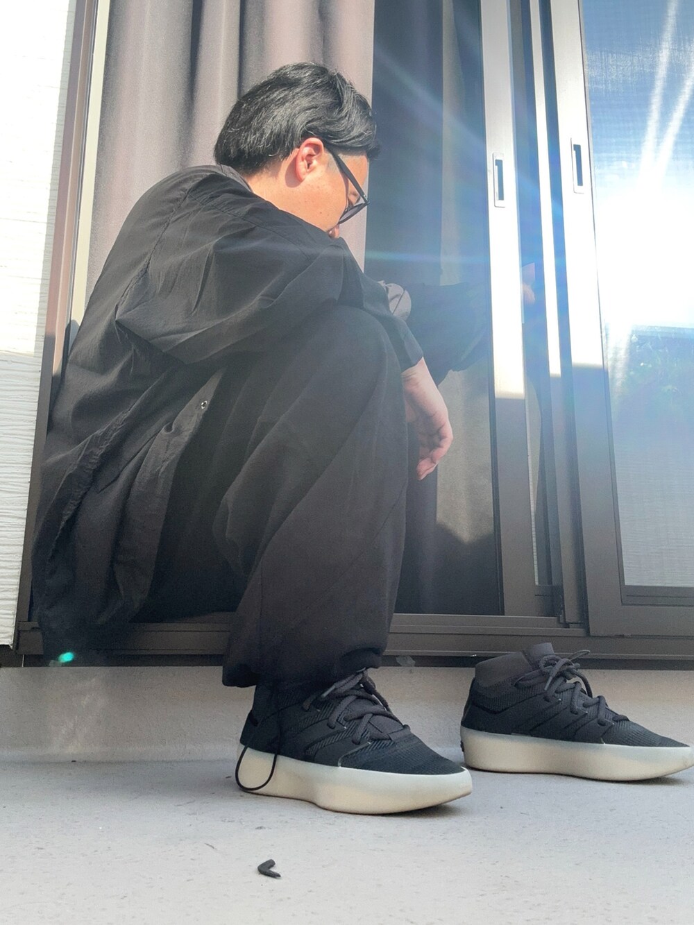 ブラック系のブルゾン、ホワイト系のTシャツ/カットソー、ブラック系のスウェットパンツを着用したメンズの秋コーディネートの3枚目の写真