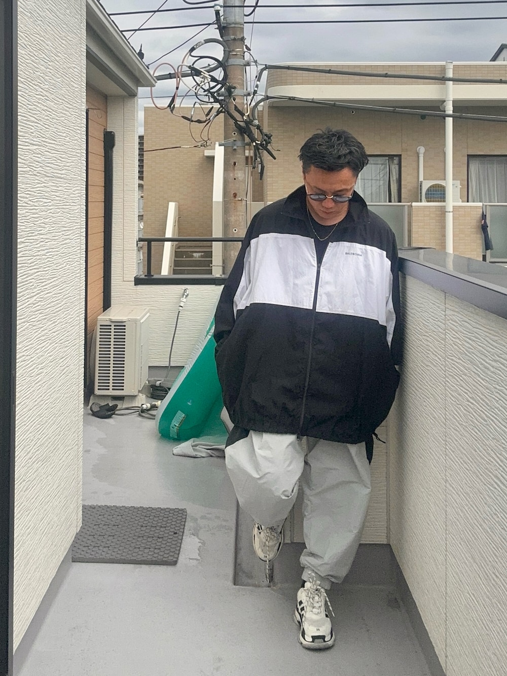 グレー系のその他パンツ、ブラック系のTシャツ/カットソー、ブラック系のナイロンジャケットを着用したメンズの秋コーディネートの2枚目の写真