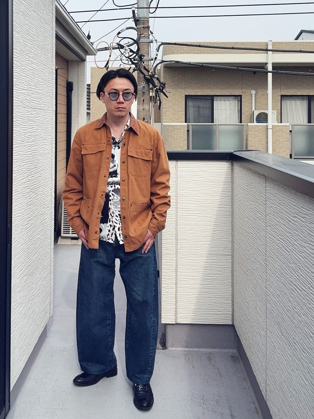 ブラック系のローファー、ホワイト系のシャツ/ブラウス、ブラウン系のカバーオールを着用したメンズの春コーディネートの2枚目の写真