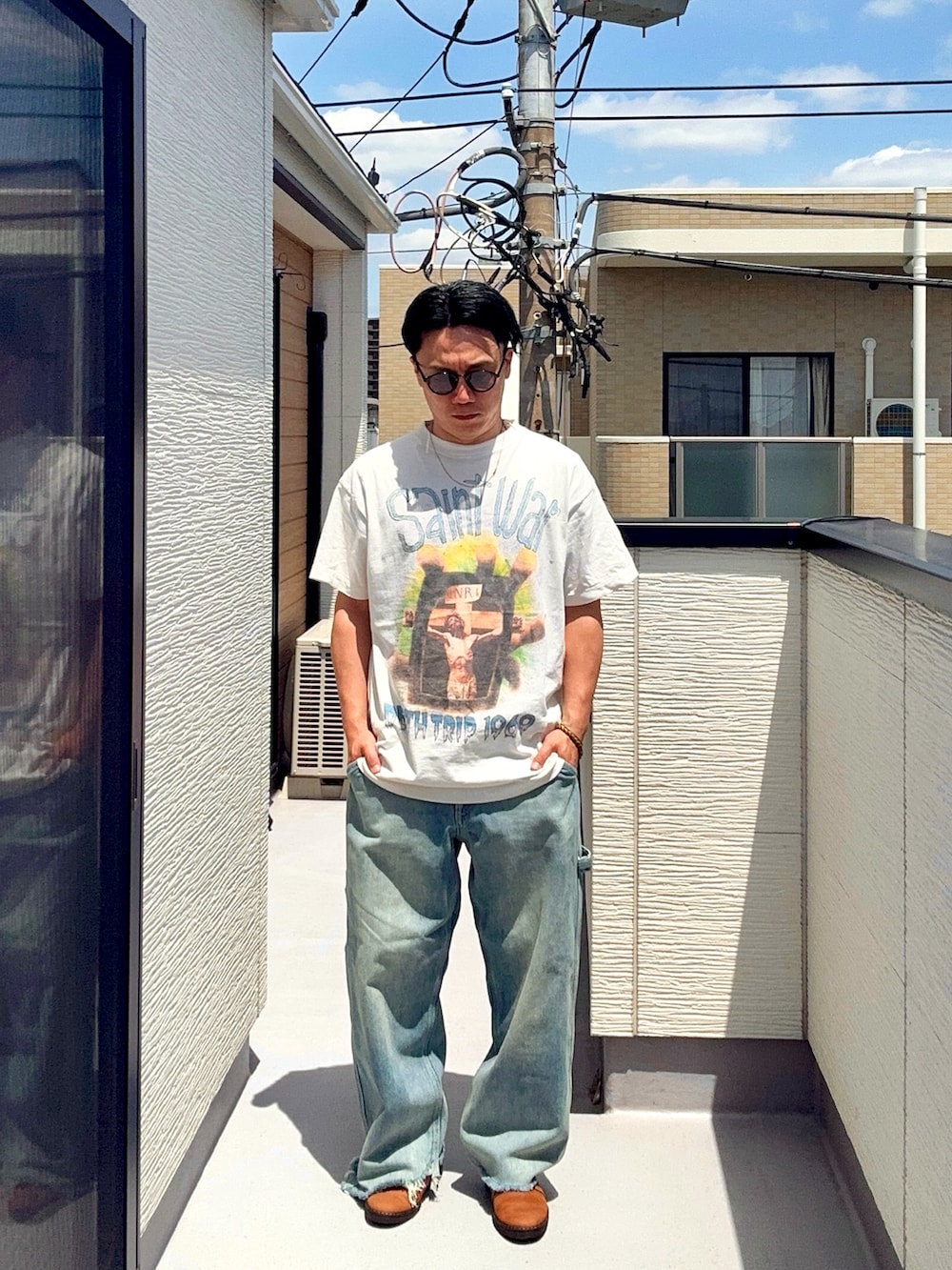 ブルー系のデニムパンツ、ホワイト系のTシャツ/カットソー、ブラウン系のドレスシューズを着用したメンズの春コーディネートの2枚目の写真