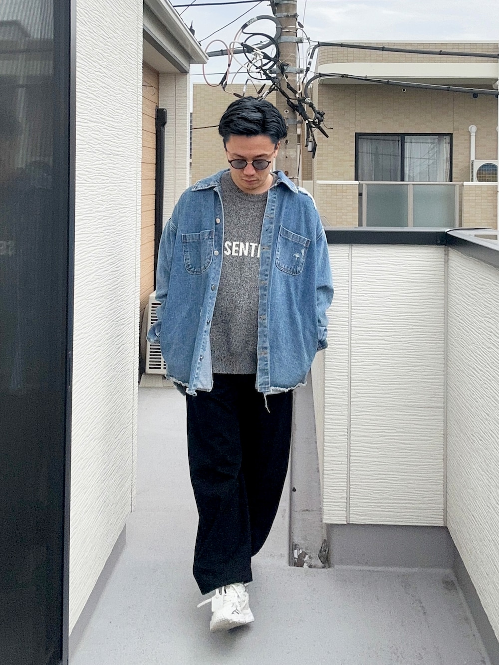 グレー系のニット/セーター、ブルー系のデニムジャケット、ブラック系のパンツを着用したメンズの冬コーディネートの2枚目の写真