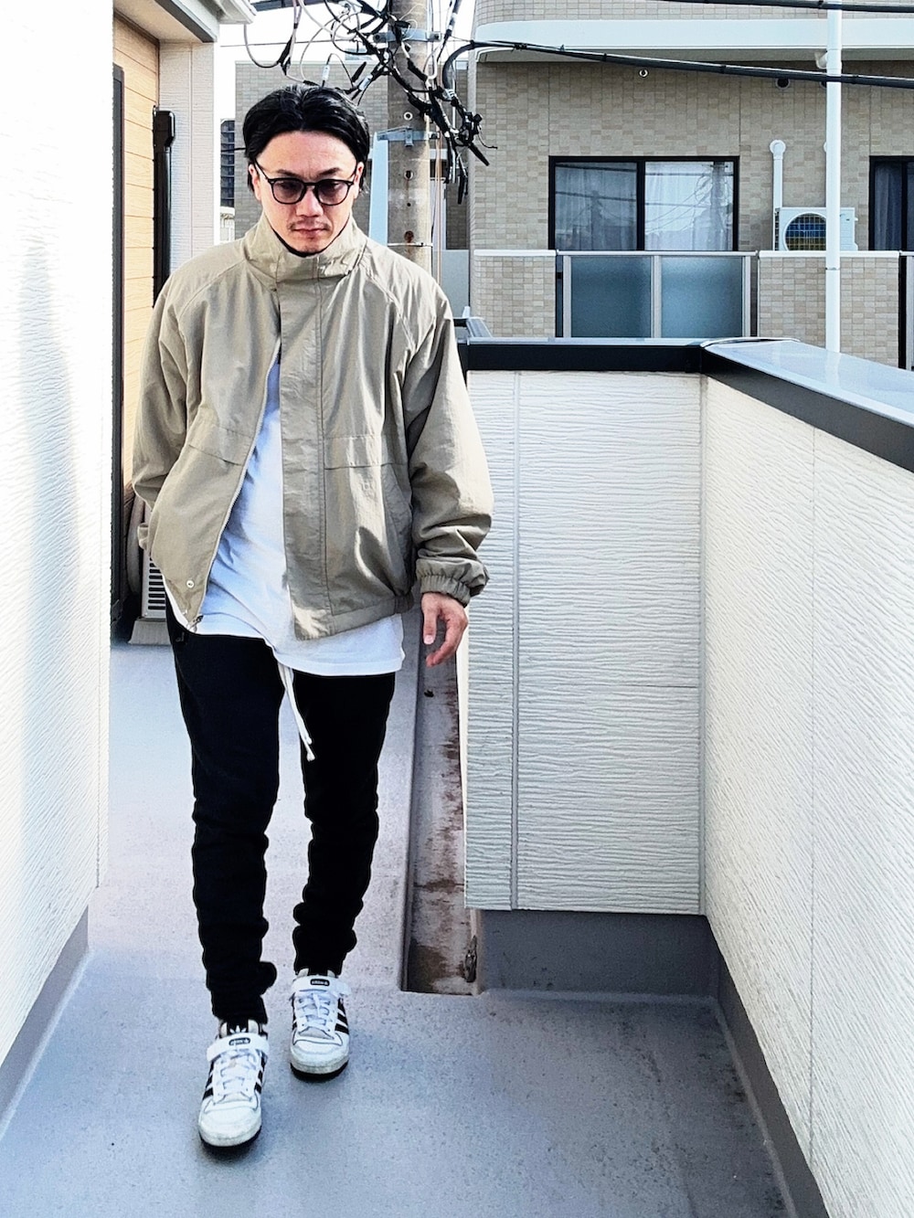 ベージュ系のブルゾン、ホワイト系のTシャツ/カットソー、ブラック系のパンツを着用したメンズの秋コーディネートの3枚目の写真