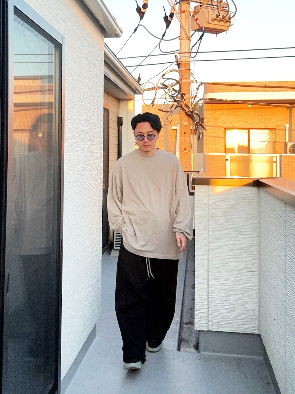 グレー系のTシャツ/カットソー、ブラック系のスウェットパンツ、ブラック系のスニーカーを着用したメンズの秋コーディネートの2枚目の写真