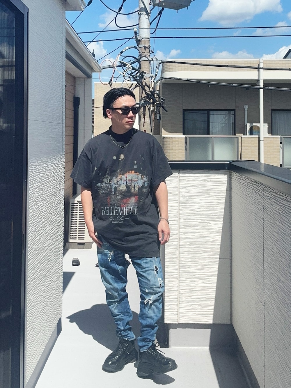 ブルー系のデニムパンツ、ブラック系のTシャツ/カットソー、ブラック系のシューズを着用したメンズの夏コーディネートの2枚目の写真