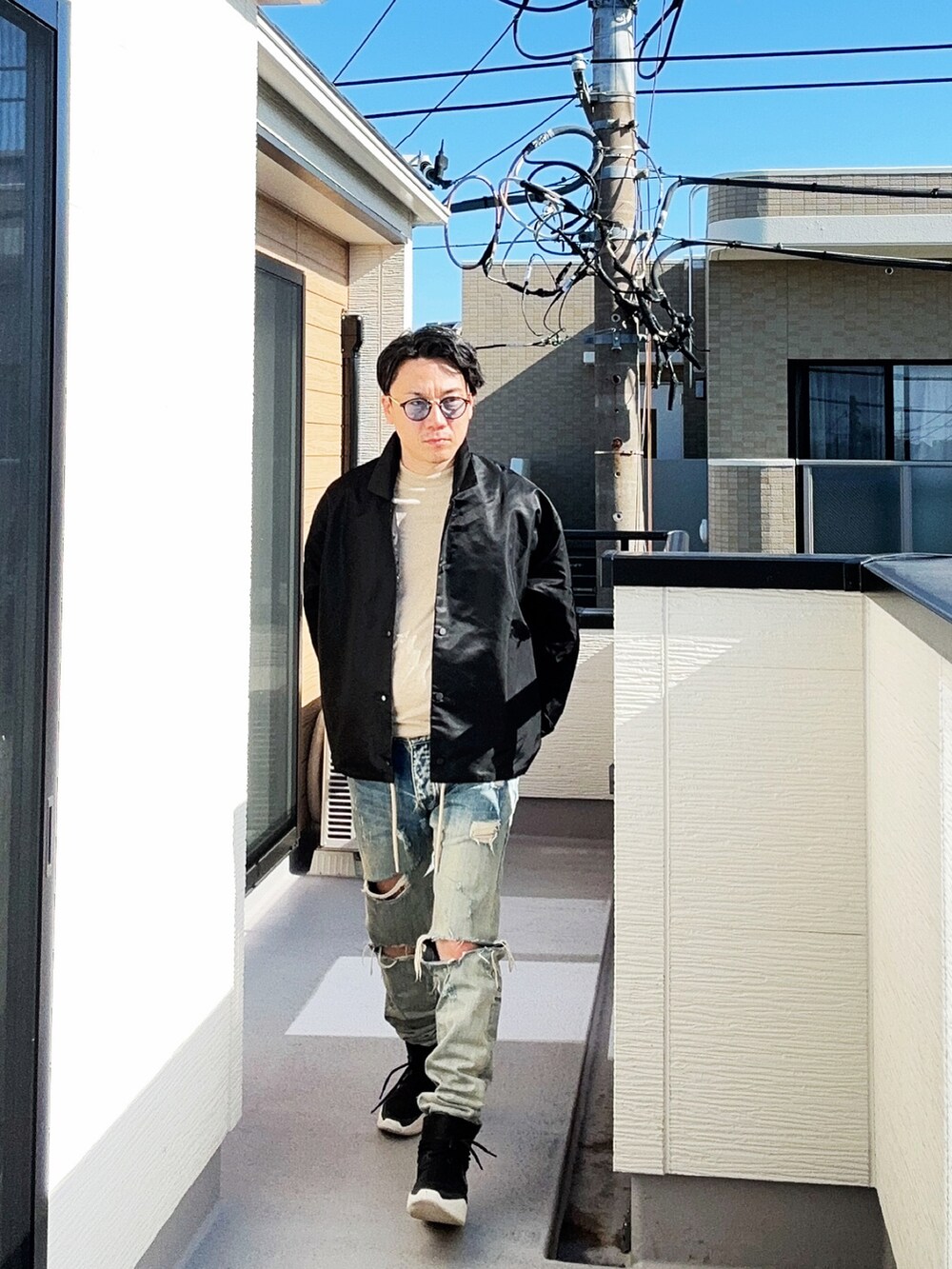 ブラック系のナイロンジャケット、グレー系のTシャツ/カットソー、ブルー系のデニムパンツを着用したメンズの秋コーディネートの2枚目の写真