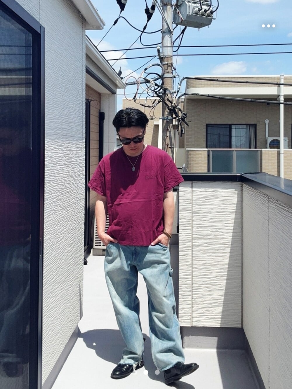 ブルー系のデニムパンツ、レッド系のTシャツ/カットソー、ブラック系のブーツを着用したメンズの春コーディネートの2枚目の写真