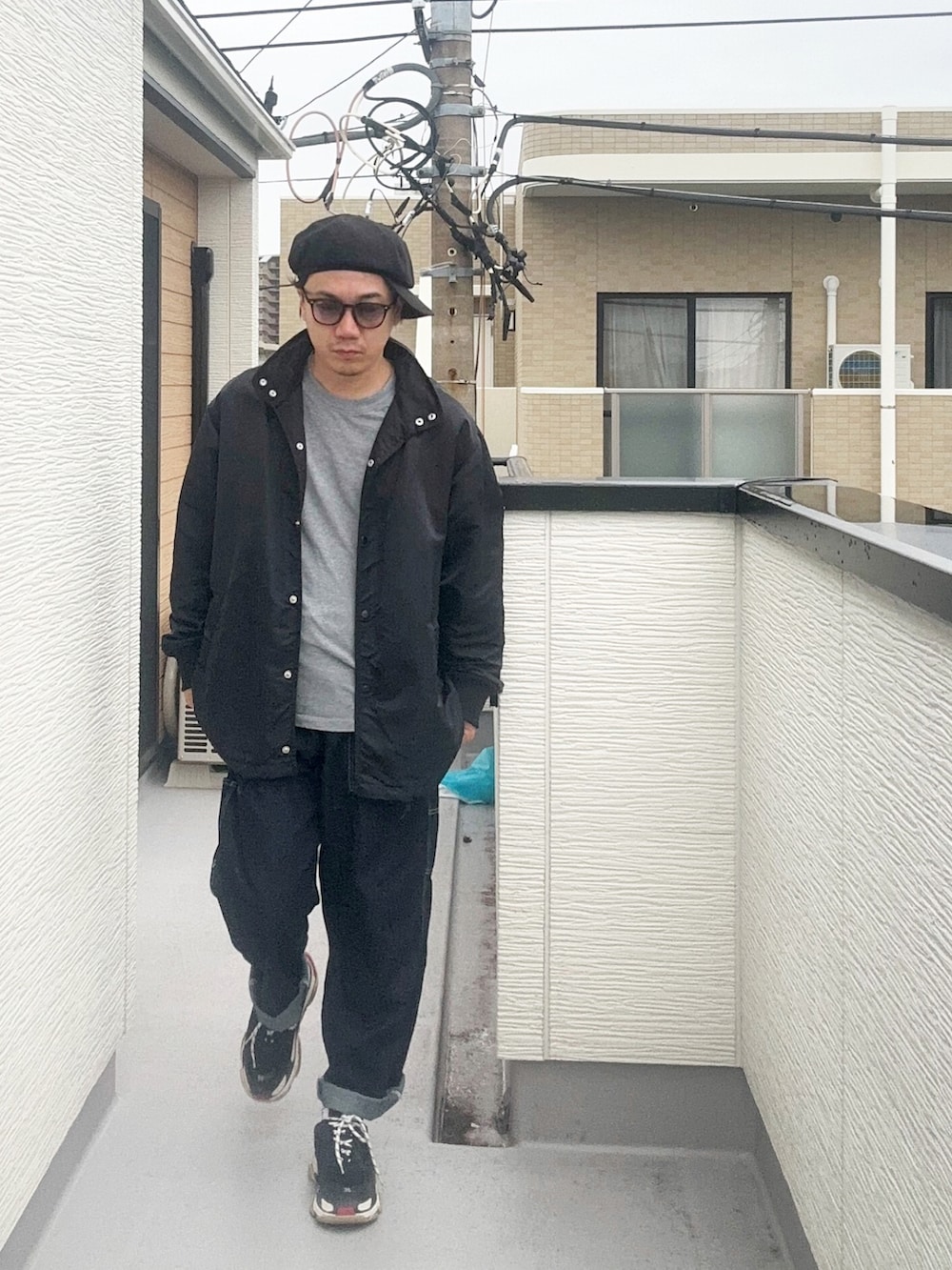 グレー系のTシャツ/カットソー、ブラック系のテーラードジャケット、ブルー系のデニムパンツを着用したメンズの秋コーディネートの2枚目の写真