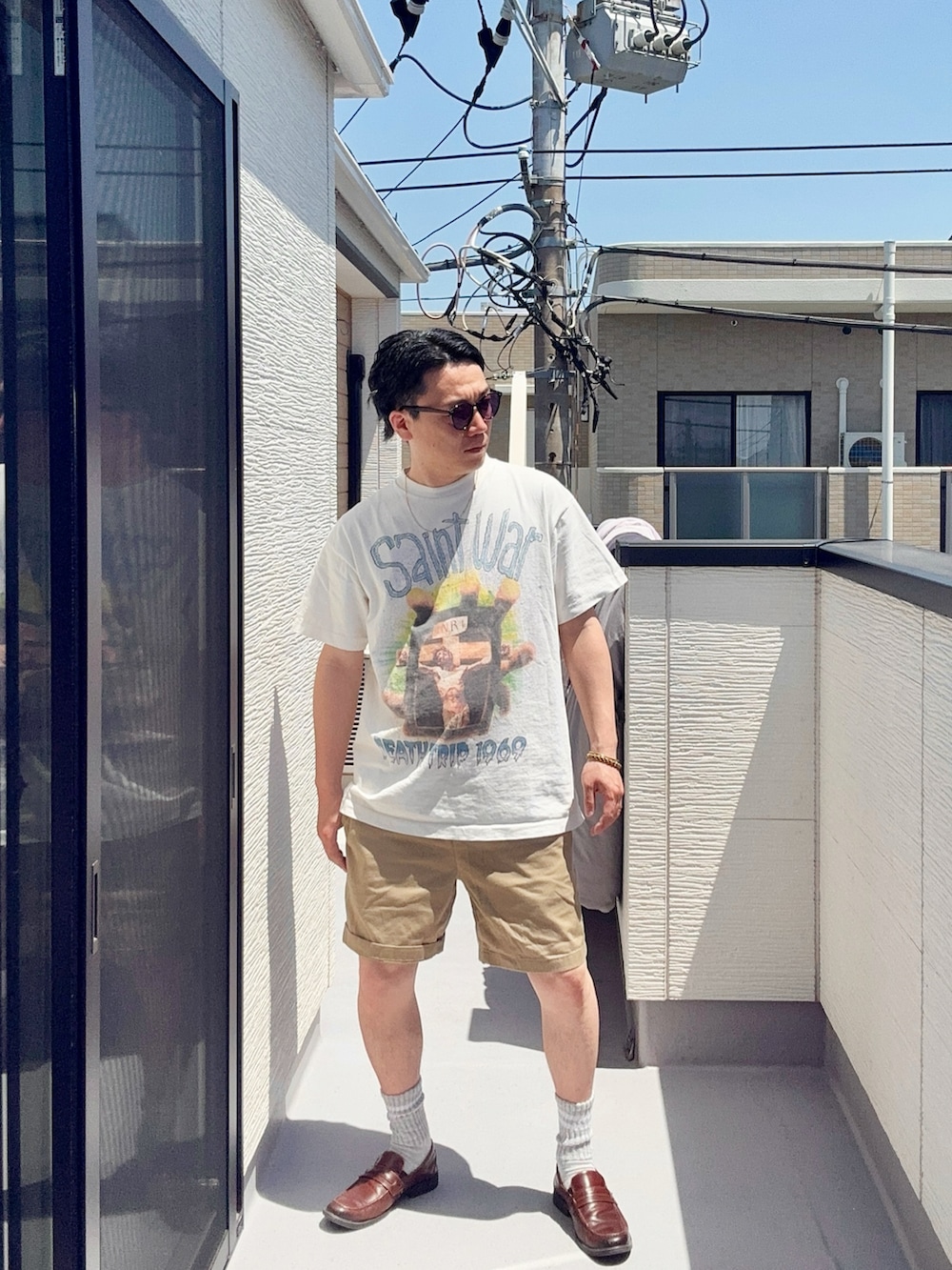 ホワイト系のTシャツ/カットソー、ベージュ系のパンツ、ブラウン系のローファーを着用したメンズの春コーディネートの4枚目の写真