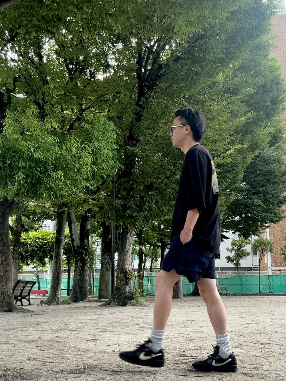 ブラック系のTシャツ/カットソー、ブルー系のパンツ、ブラック系のスニーカーを着用したメンズの夏コーディネートの3枚目の写真