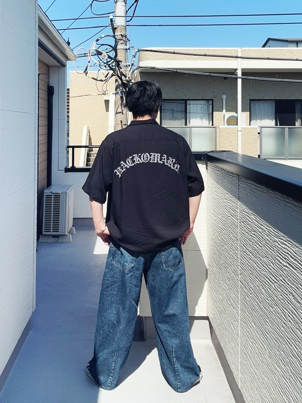 ブラック系のスニーカー、ブラック系のシャツ/ブラウス、ブルー系のデニムパンツを着用したメンズの夏コーディネートの2枚目の写真