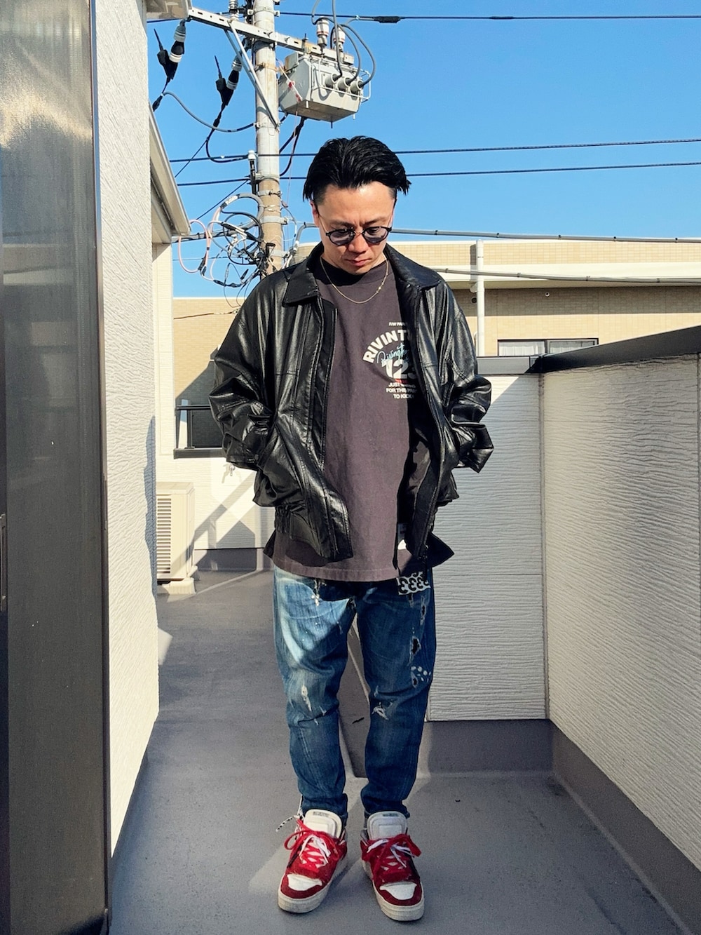 ブラック系のブルゾン、ブラック系のTシャツ/カットソー、ブルー系のデニムパンツを着用したメンズの冬コーディネートの2枚目の写真