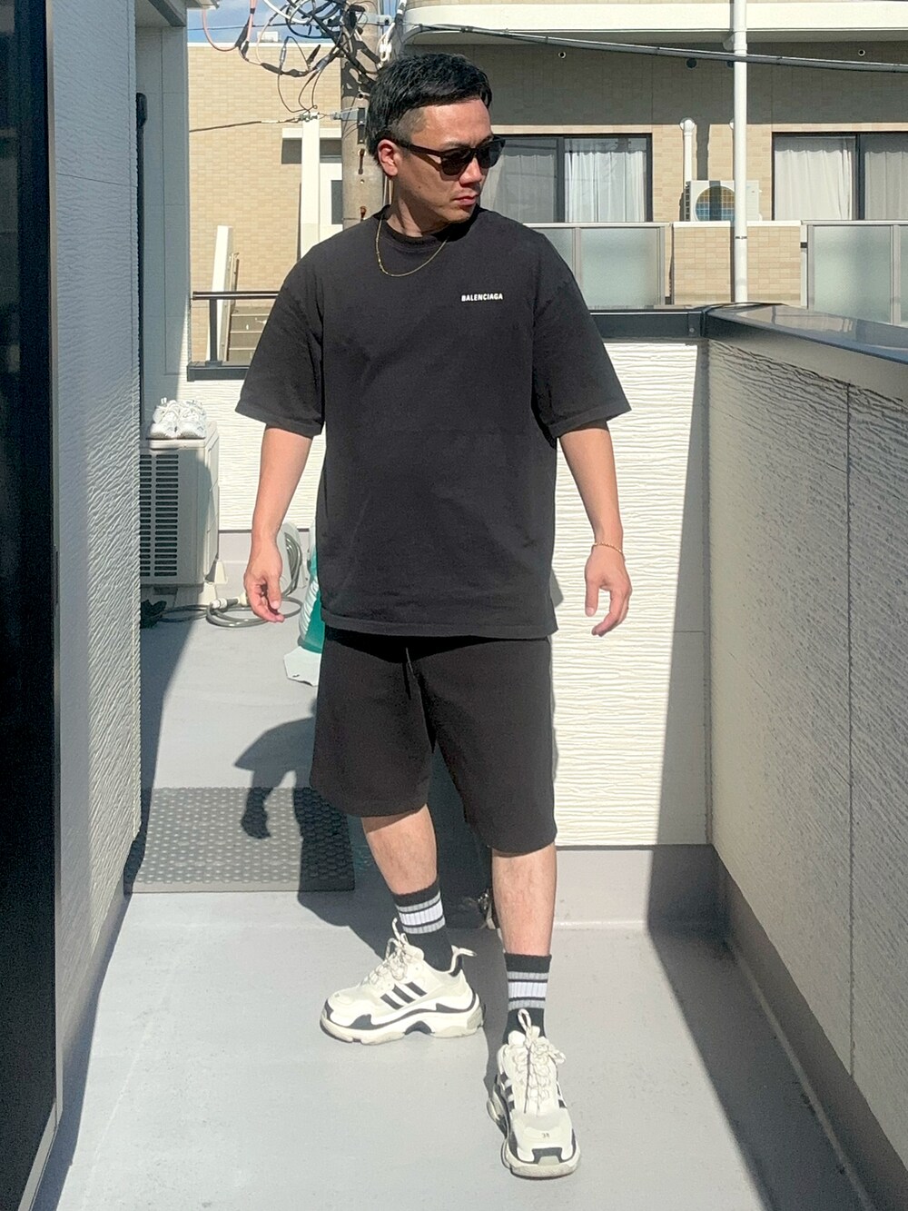 ブラック系のTシャツ/カットソー、ブラック系のスウェットパンツ、ホワイト系のシューズを着用したメンズの秋コーディネートの3枚目の写真