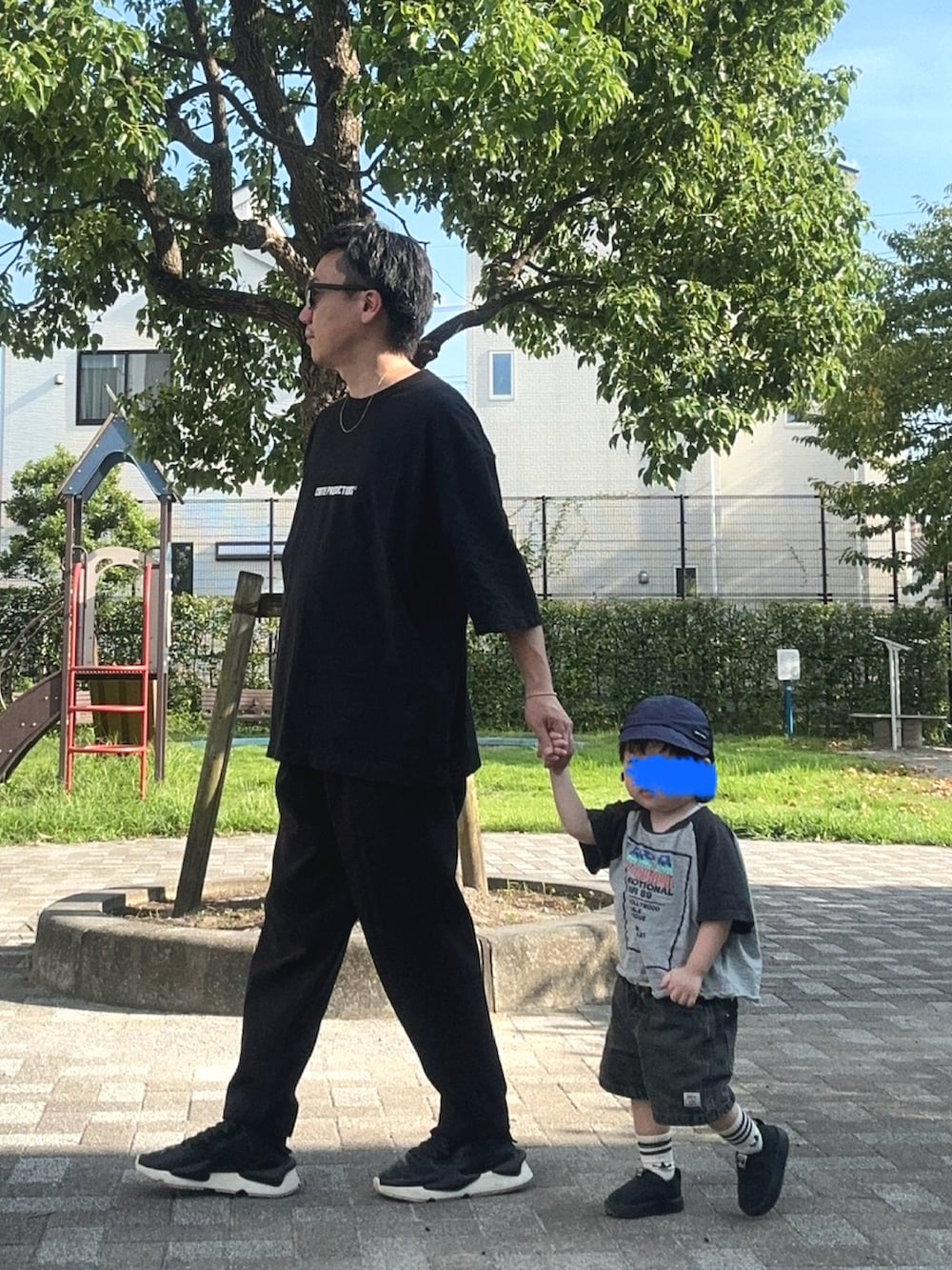 グレー系のTシャツ/カットソー、ブラック系のスニーカー、ブラック系のスラックスを着用したメンズの夏コーディネートの3枚目の写真