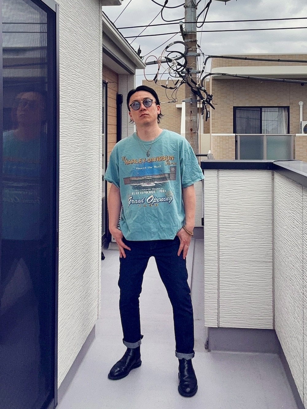 ブルー系のTシャツ/カットソー、ブルー系のデニムパンツ、ブラック系のブーツを着用したメンズの夏コーディネートの3枚目の写真
