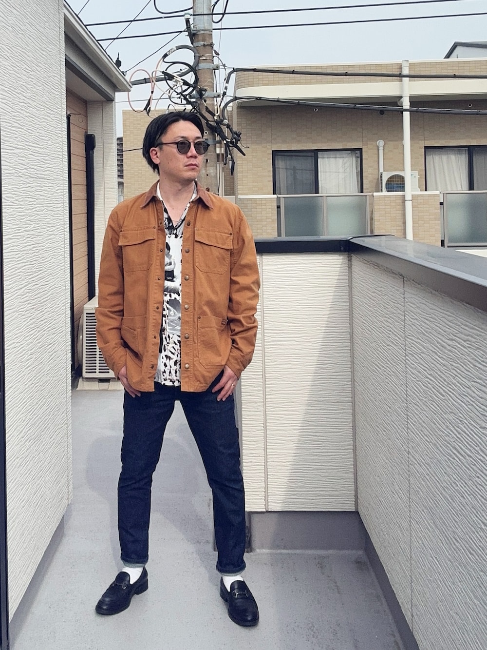 ブラック系のローファー、ホワイト系のシャツ/ブラウス、ブラウン系のカバーオールを着用したメンズの春コーディネートの2枚目の写真