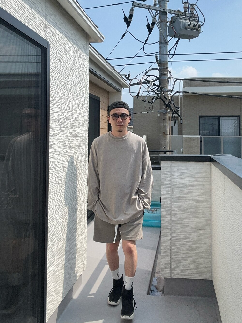 グレー系のTシャツ/カットソー、グレー系のスウェットパンツ、ブラック系のスニーカーを着用したメンズの秋コーディネートの3枚目の写真