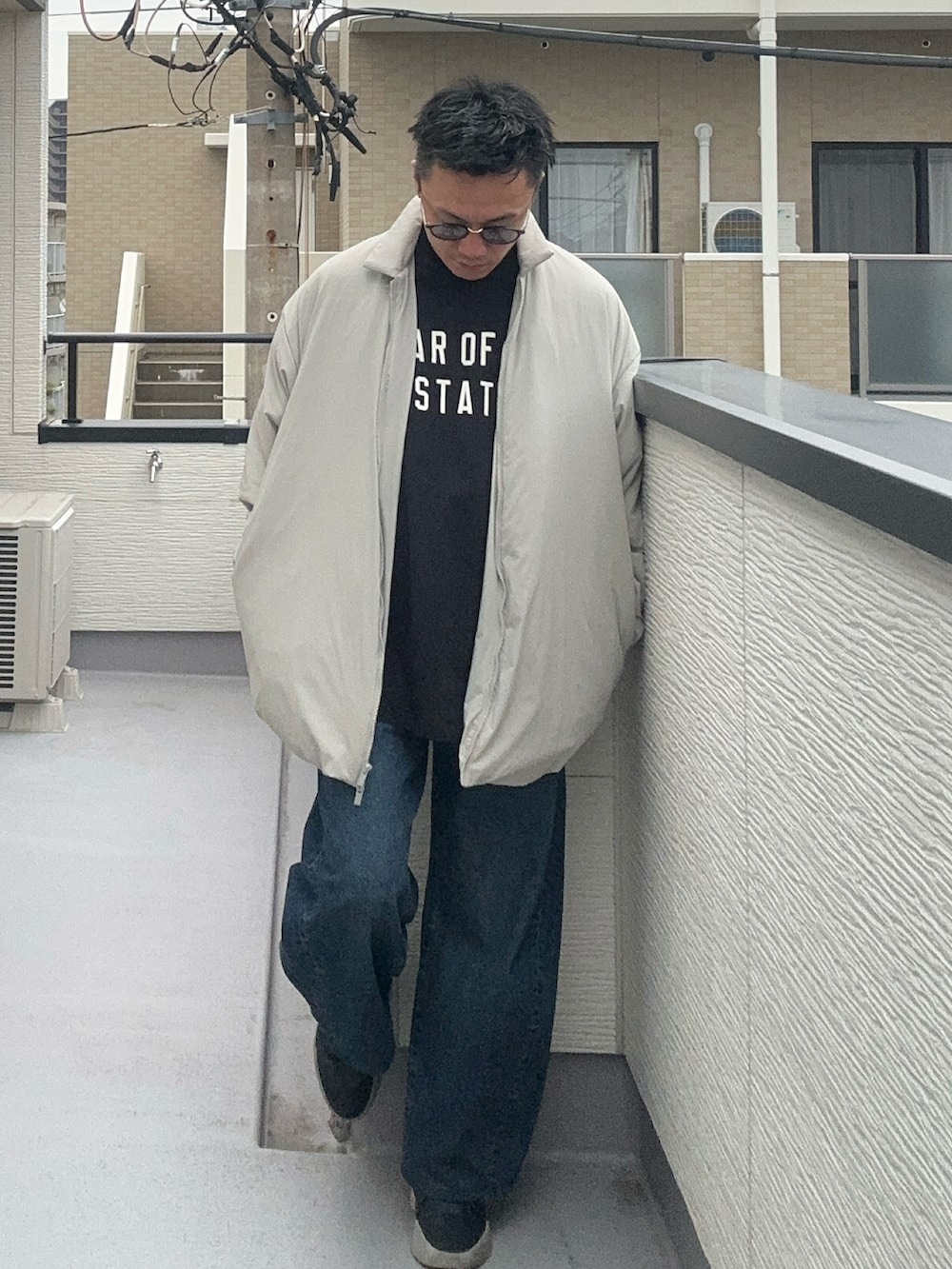 ブラック系のTシャツ/カットソー、ブラック系のその他アウター、ブルー系のデニムパンツを着用したメンズの秋コーディネートの2枚目の写真
