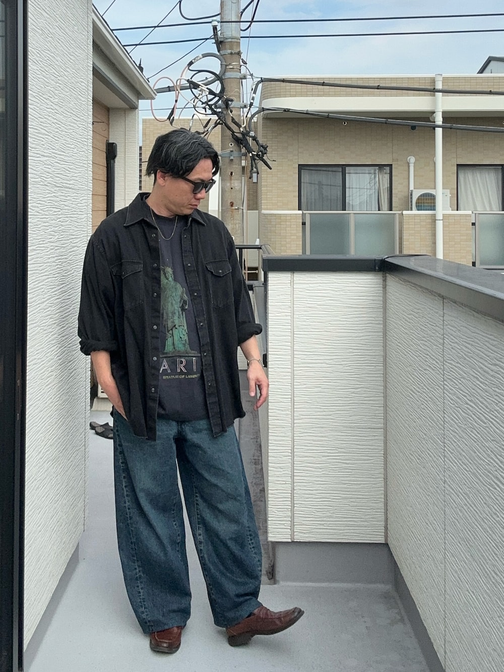 ブラック系のTシャツ/カットソー、ブラック系のシャツ/ブラウス、ブルー系のデニムパンツを着用したメンズの秋コーディネートの2枚目の写真