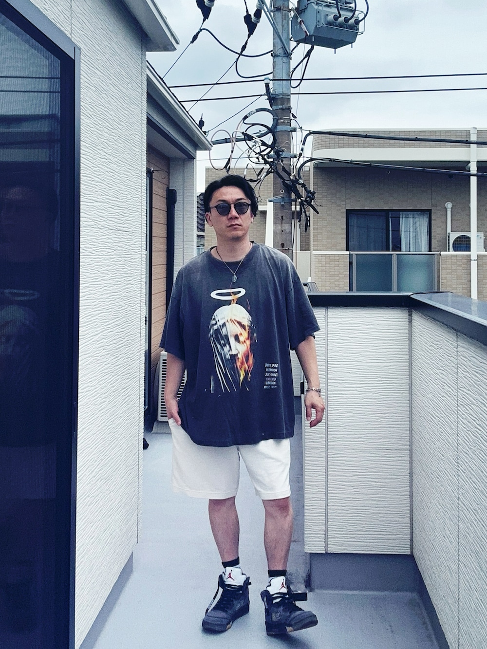 ブラック系のTシャツ/カットソー、ホワイト系のパンツ、グレー系のスニーカーを着用したメンズの夏コーディネートの2枚目の写真