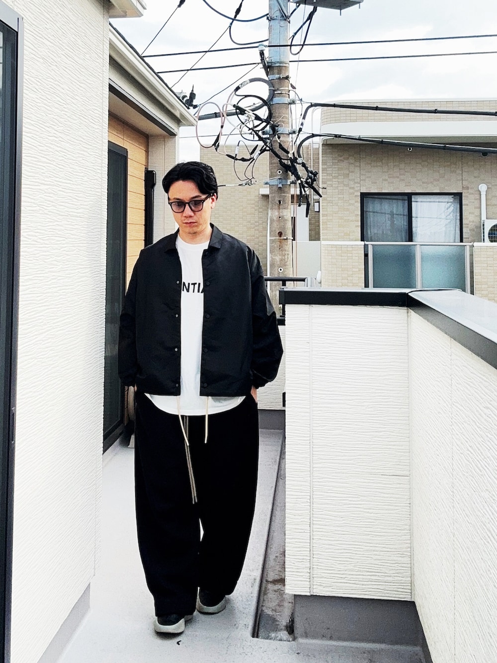 ブラック系のナイロンジャケット、ブラック系のスウェットパンツ、ホワイト系のTシャツ/カットソーを着用したメンズの秋コーディネートの3枚目の写真