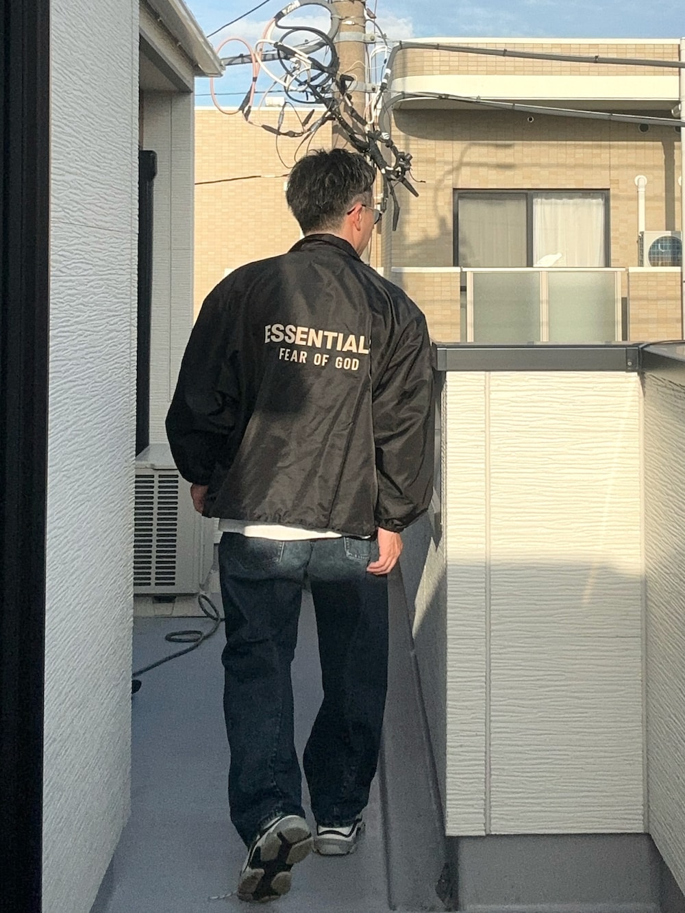 ブラック系のナイロンジャケット、ホワイト系のTシャツ/カットソー、ブルー系のデニムパンツを着用したメンズの秋コーディネートの3枚目の写真