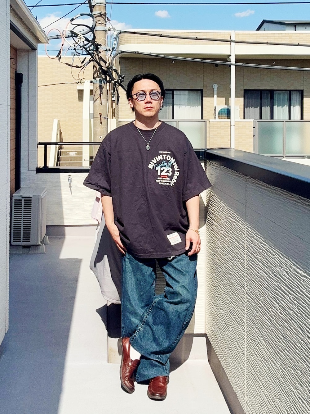 ブラック系のTシャツ/カットソー、ブルー系のデニムパンツ、ブラウン系のローファーを着用したメンズの春コーディネートの2枚目の写真