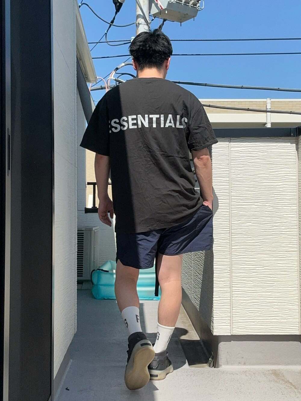 ブルー系のパンツ、ブラック系のTシャツ/カットソー、ブラック系のスニーカーを着用したメンズの夏コーディネートの5枚目の写真