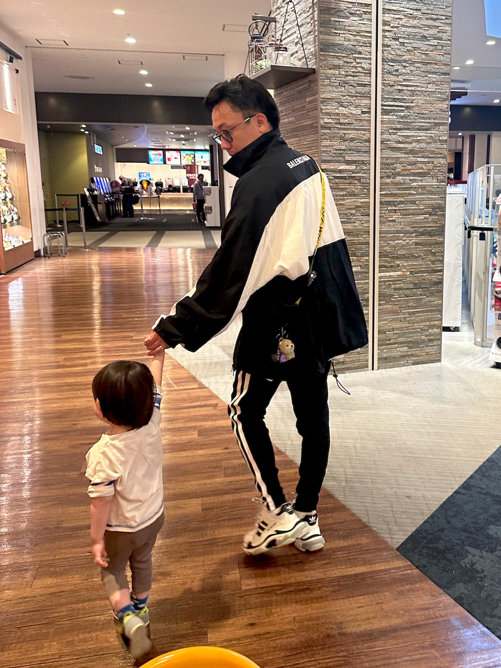 ブラック系のショルダーバッグ、ブラック系のスニーカー、ホワイト系のトップスを着用したメンズの秋コーディネートの3枚目の写真