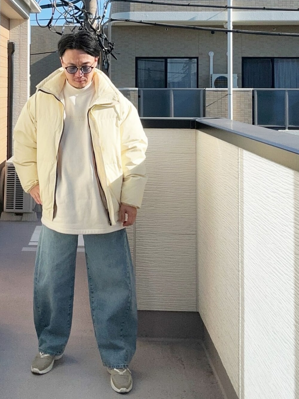 ベージュ系のスウェット、ベージュ系のダウンジャケット/コート、ブルー系のデニムパンツを着用したメンズの冬コーディネートの3枚目の写真