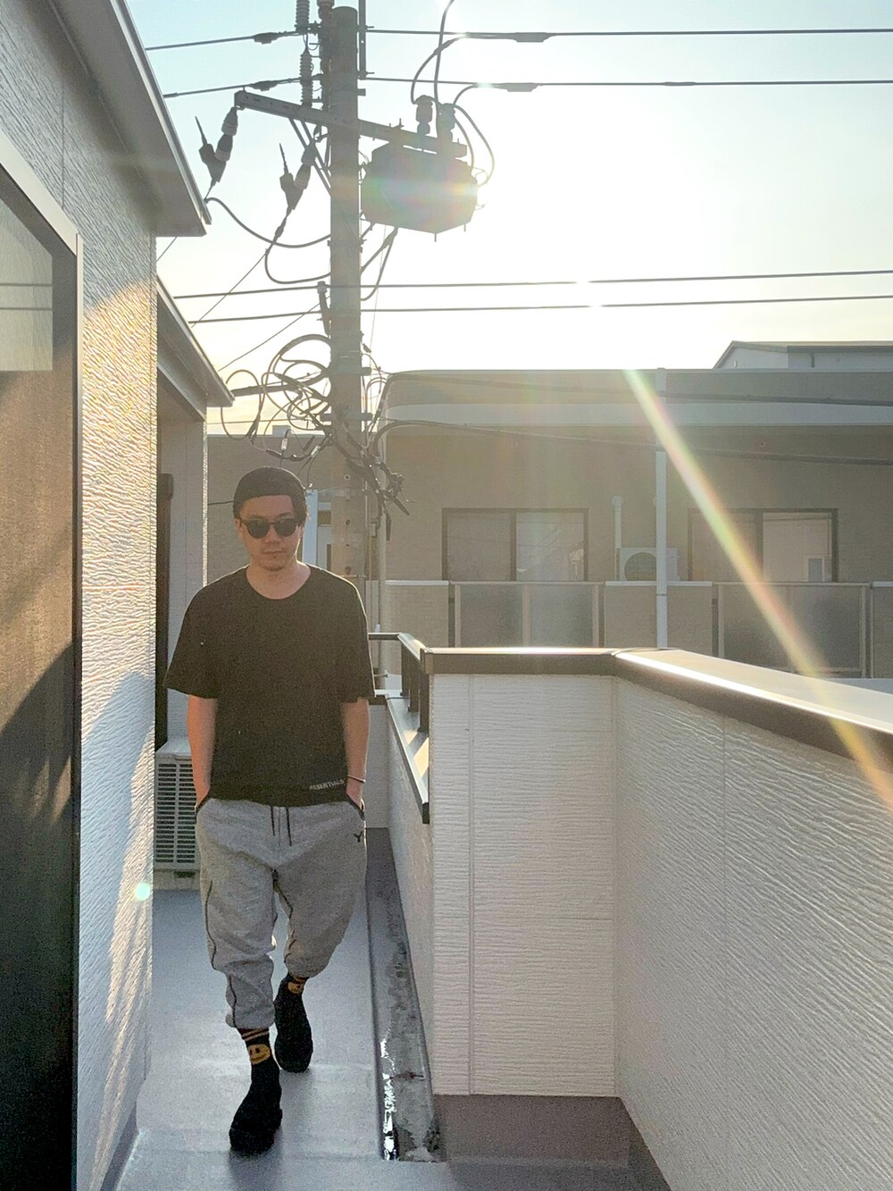 ブラック系のTシャツ/カットソー、グレー系のパンツ、ブラック系のサンダルを着用したメンズの夏コーディネートの4枚目の写真