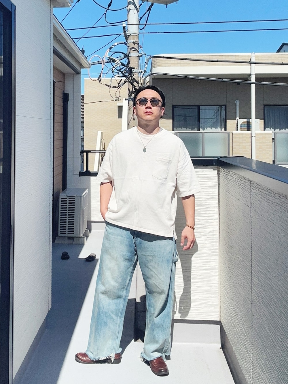 ブルー系のデニムパンツ、ホワイト系のTシャツ/カットソー、ブラウン系のローファーを着用したメンズの夏コーディネートの4枚目の写真