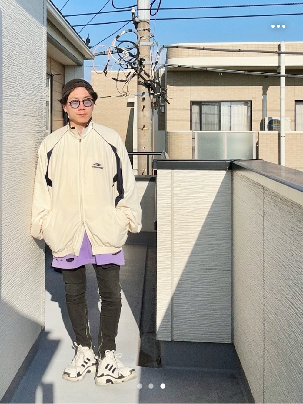 パープル系のTシャツ/カットソー、ホワイト系のナイロンジャケット、ブラック系のデニムパンツを着用したメンズの秋コーディネートの3枚目の写真