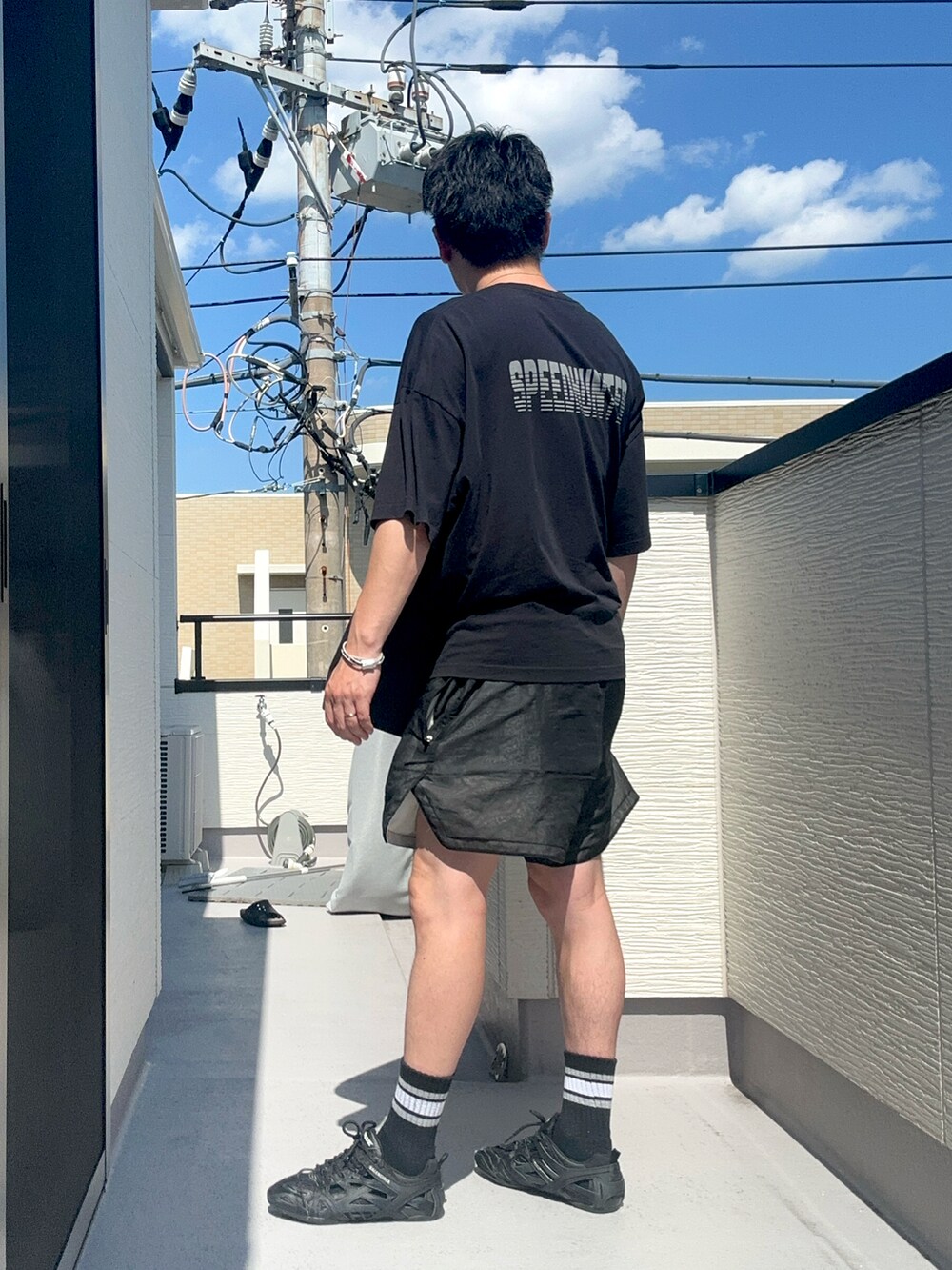 ブラック系のTシャツ/カットソー、ブラック系のパンツ、ブラック系のシューズを着用したメンズの夏コーディネートの3枚目の写真
