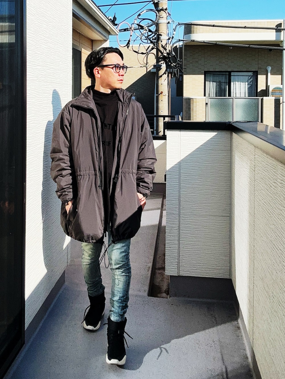 ブラック系のTシャツ/カットソー、ブラック系のその他アウター、ブルー系のデニムパンツを着用したメンズの秋コーディネートの3枚目の写真