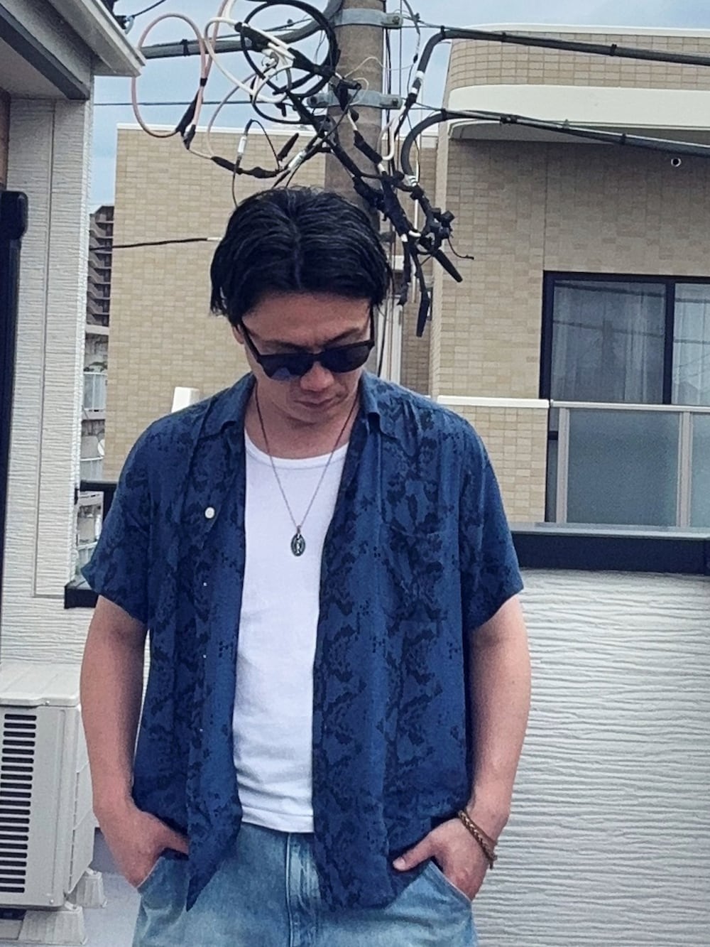 ブルー系のデニムパンツ、ブラック系のローファー、ホワイト系のタンクトップを着用したメンズの夏コーディネートの3枚目の写真