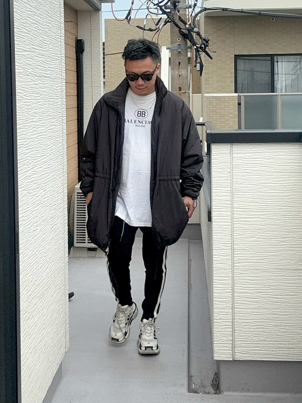 ブラック系のその他アウター、ホワイト系のTシャツ/カットソー、ブラック系のパンツを着用したメンズの秋コーディネートの2枚目の写真